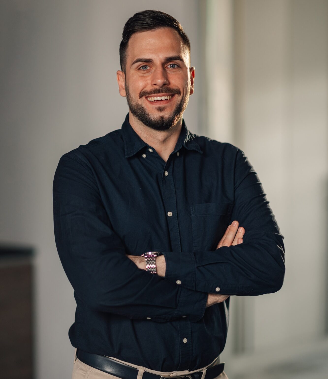 Portrait of happy confident CEO with arms crossed smiling at camera.